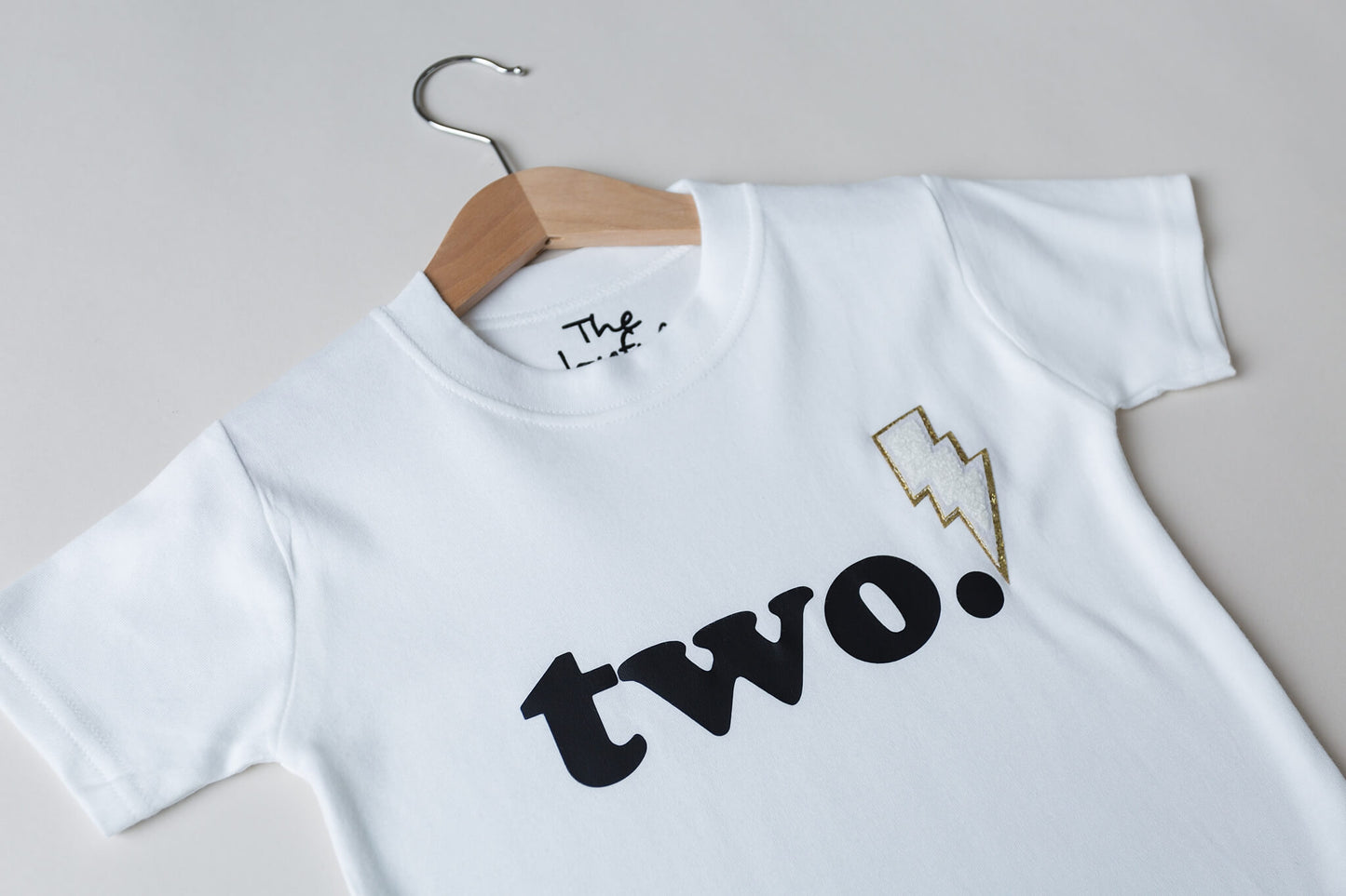 White 2nd birthday shirt - black text 'two' with lightning bolt patch