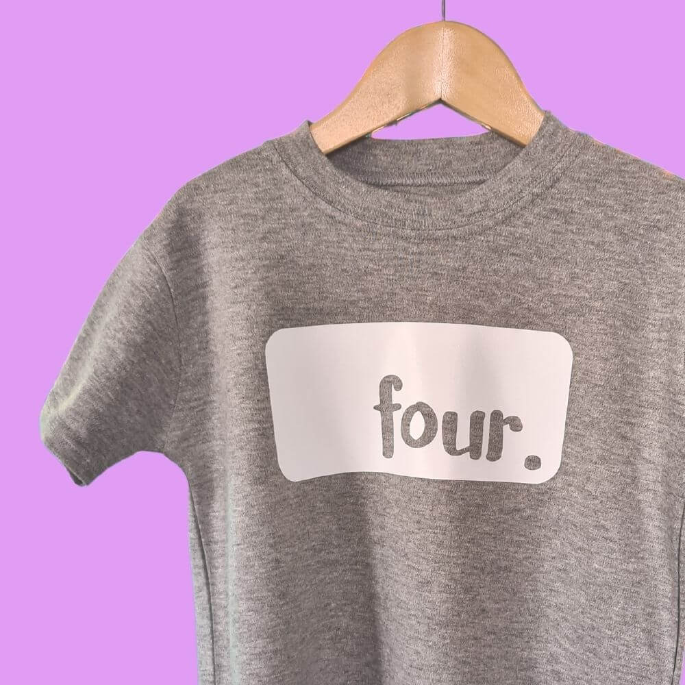 Hanging light Grey birthday tshirt from The Joyful Rebel. The t-shirt has rectangle logo with the text 'FOUR'
