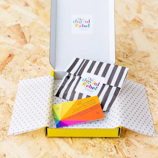 show how the badges are packaged. Striped paper bag, protected in a cardboard box.