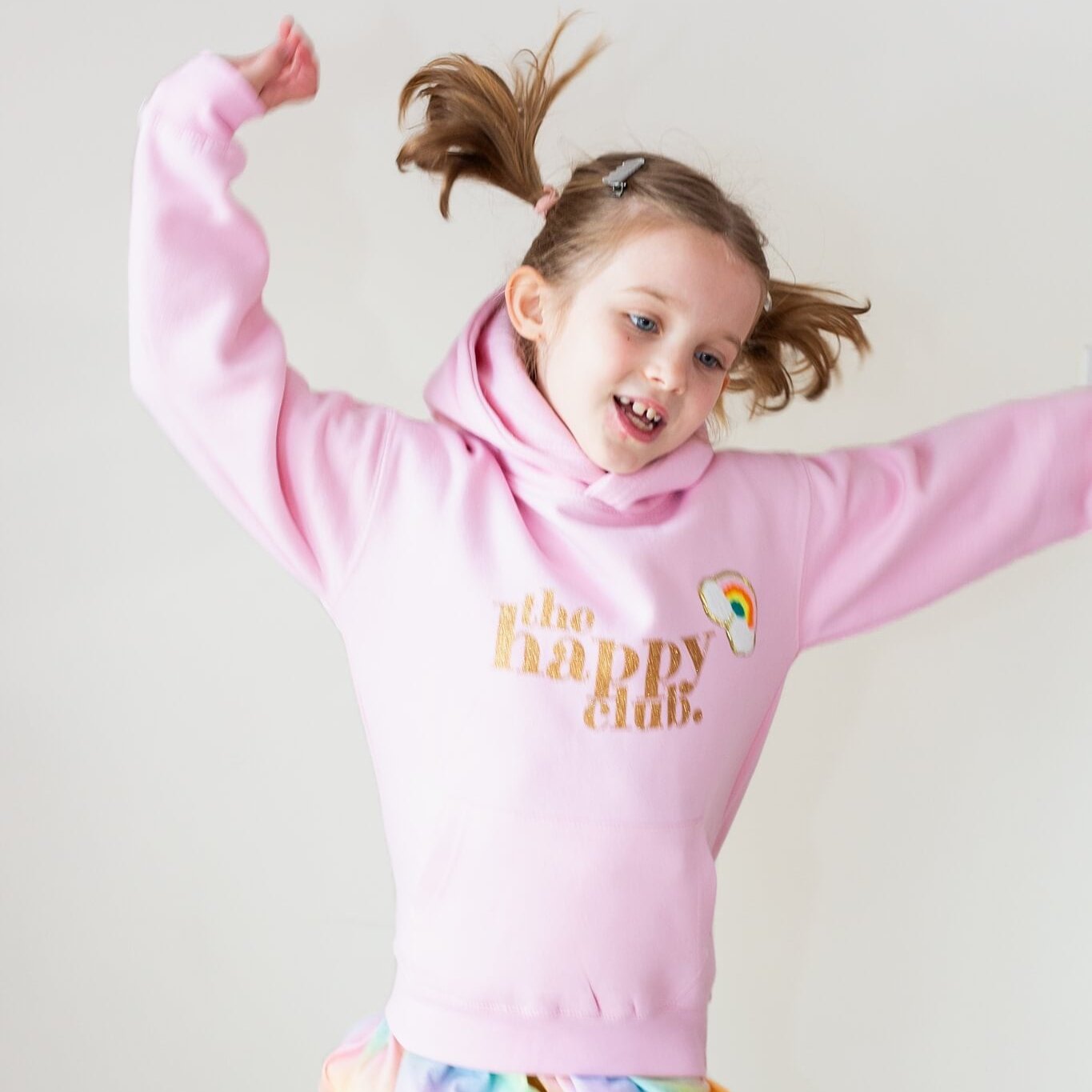 Girl jumping in the air wearing The Joyful Rebel sweatshirt