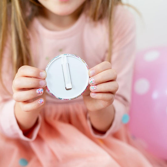 Child holding a birthday badge with the kids safety slide clip.