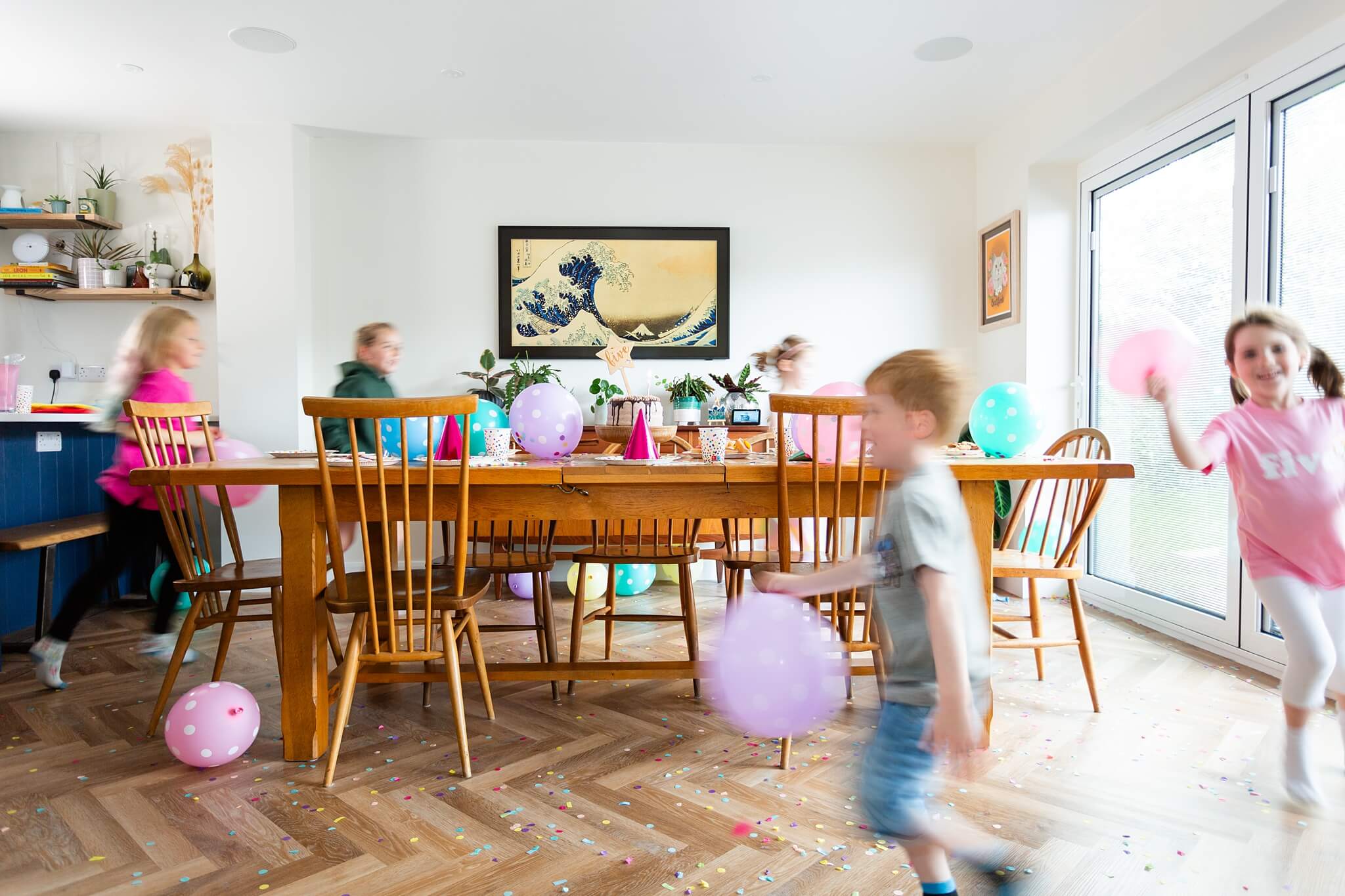 Show a blurred shot of kids running around a table - birthday party The Joyful Rebel