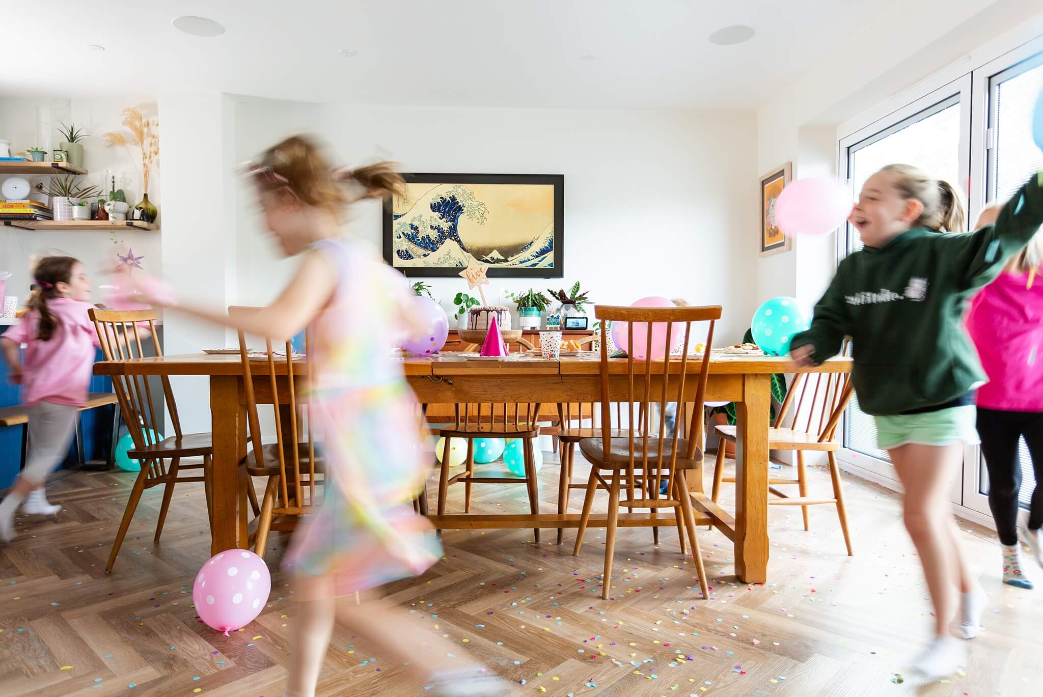 Children dressed up in The Joyful Rebel birthday t-shirt and dancing around a table