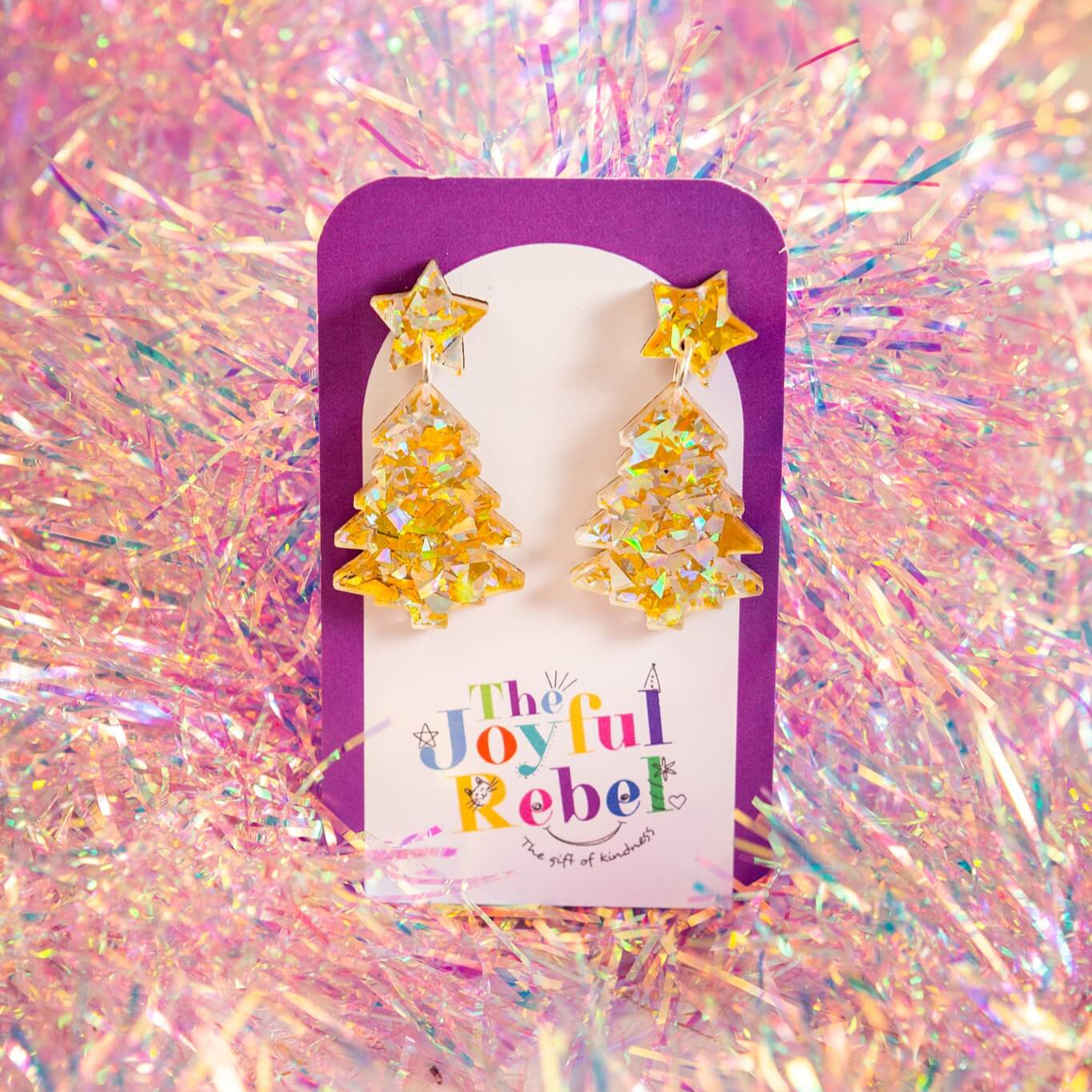 Star-shaped earrings in a 'The Joyful Rebel' branded gift box on a glittery background. Christmas Gift Wrapping