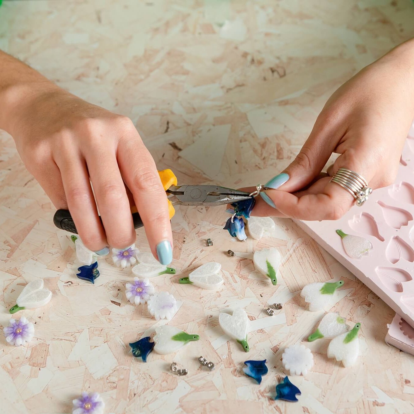 two hands putting together bluebell earrings.
