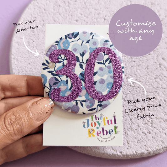 Flower print fabric birthday badge with purple glitter 30. Badge is made by The Joyful Rebel