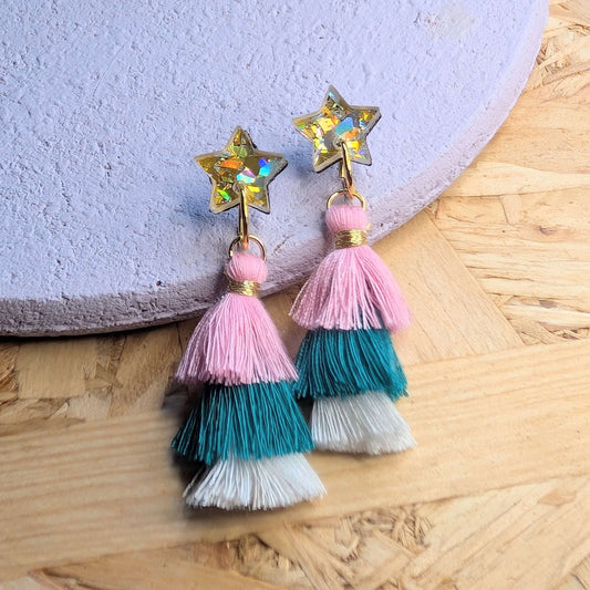 Colorful tassel earrings with star designs on a wooden surface byt The Joyful Rebel