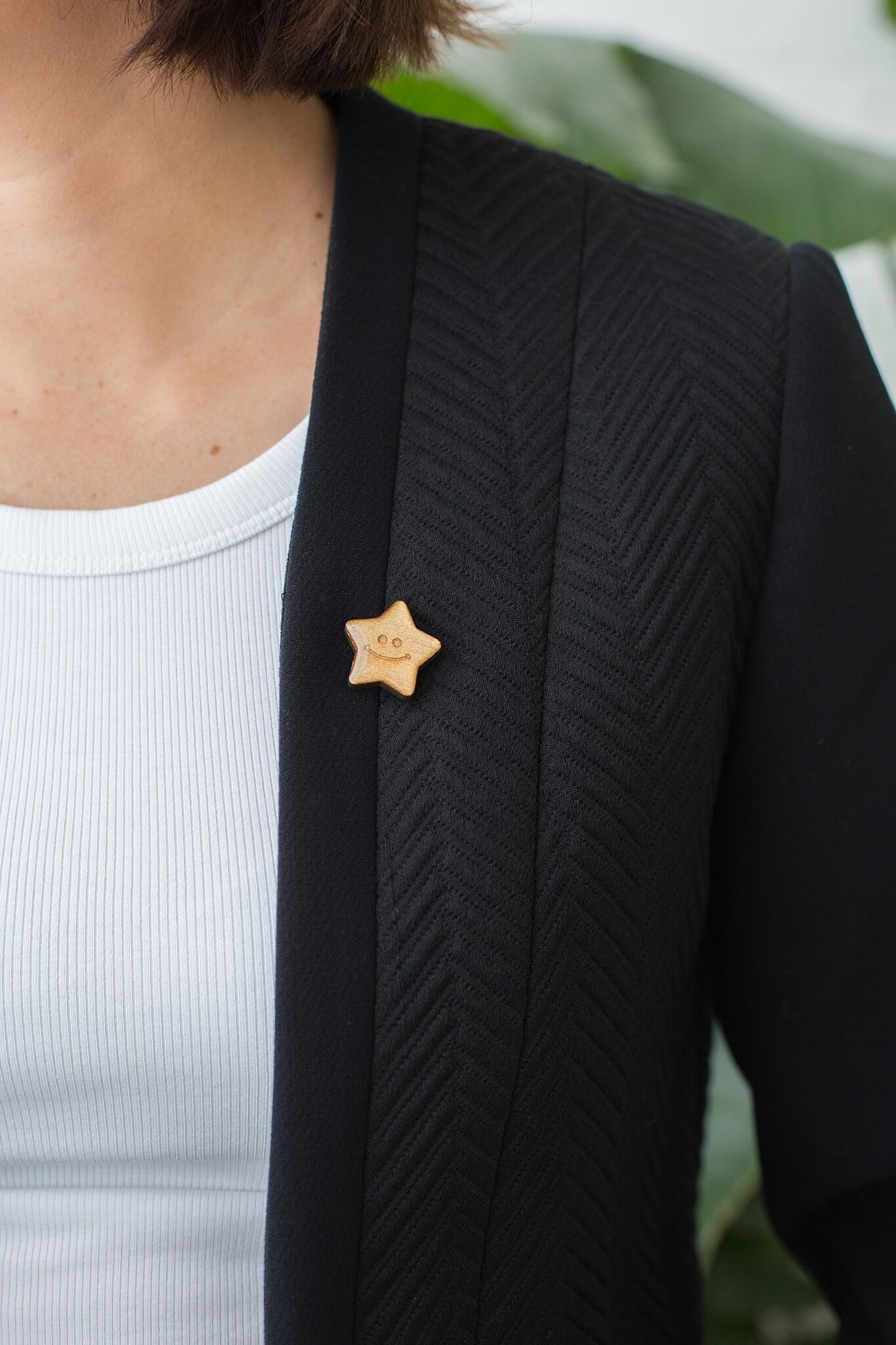 Someone wearing the gold star badge on the lapel of a black blazer