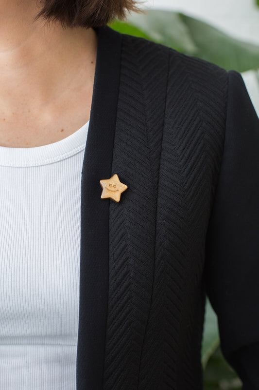 Someone wearing the gold star badge on the lapel of a black blazer