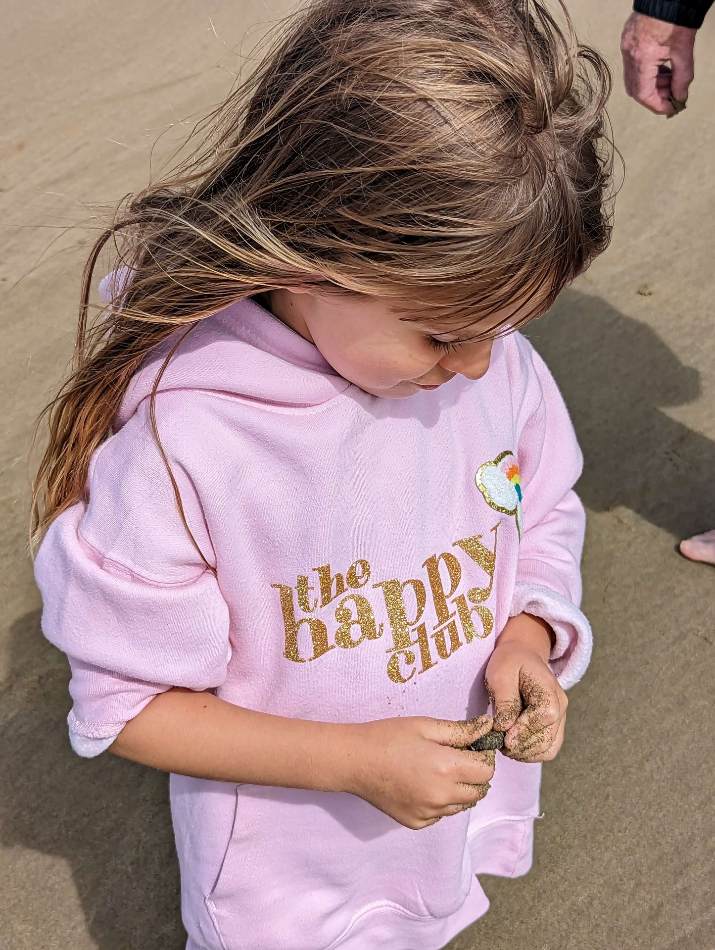 Girl wearing on pink sweatshirt on a beach