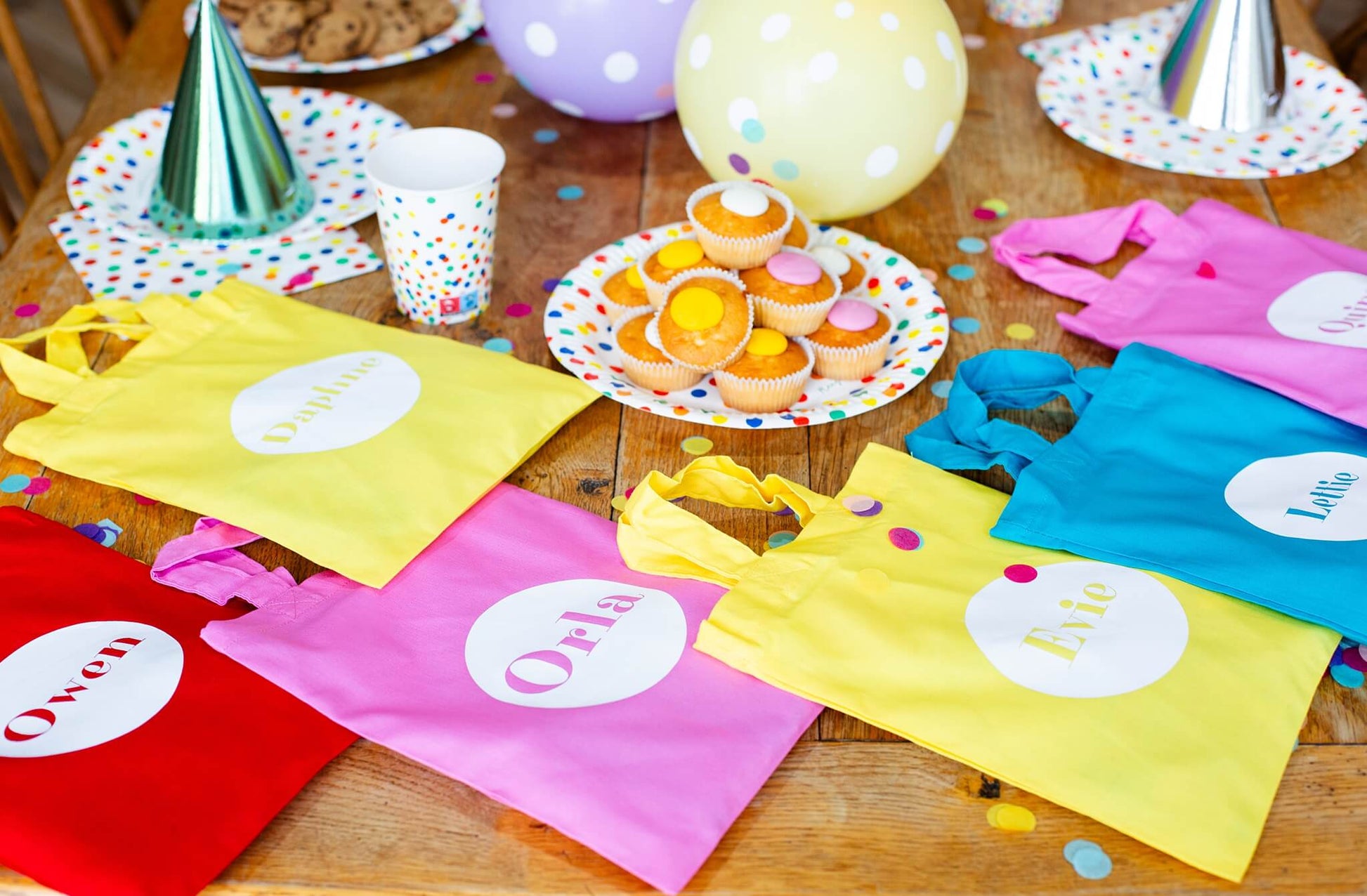 colourful party bag - blue, yellow, red and pink. The party bag bags are laid out on a table.