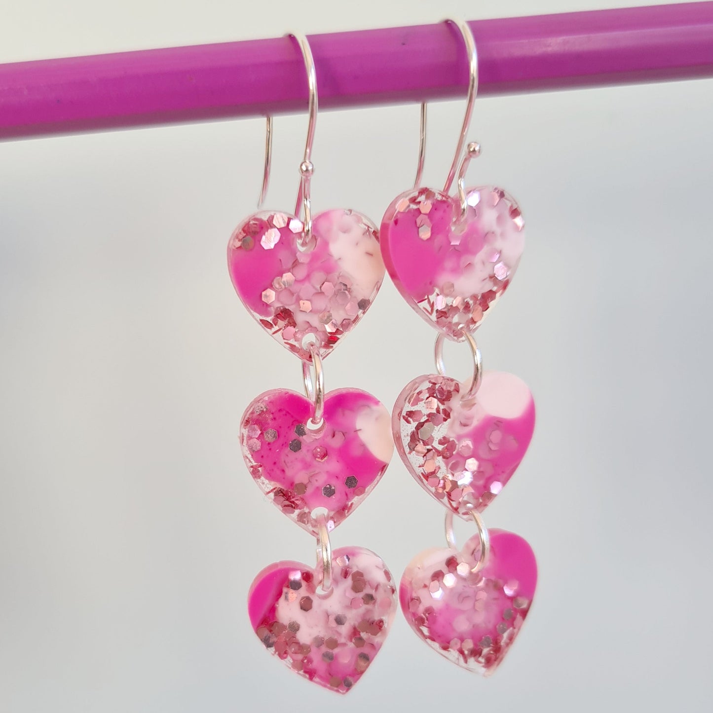 resin earrings made from pink marbled resin and glitter.