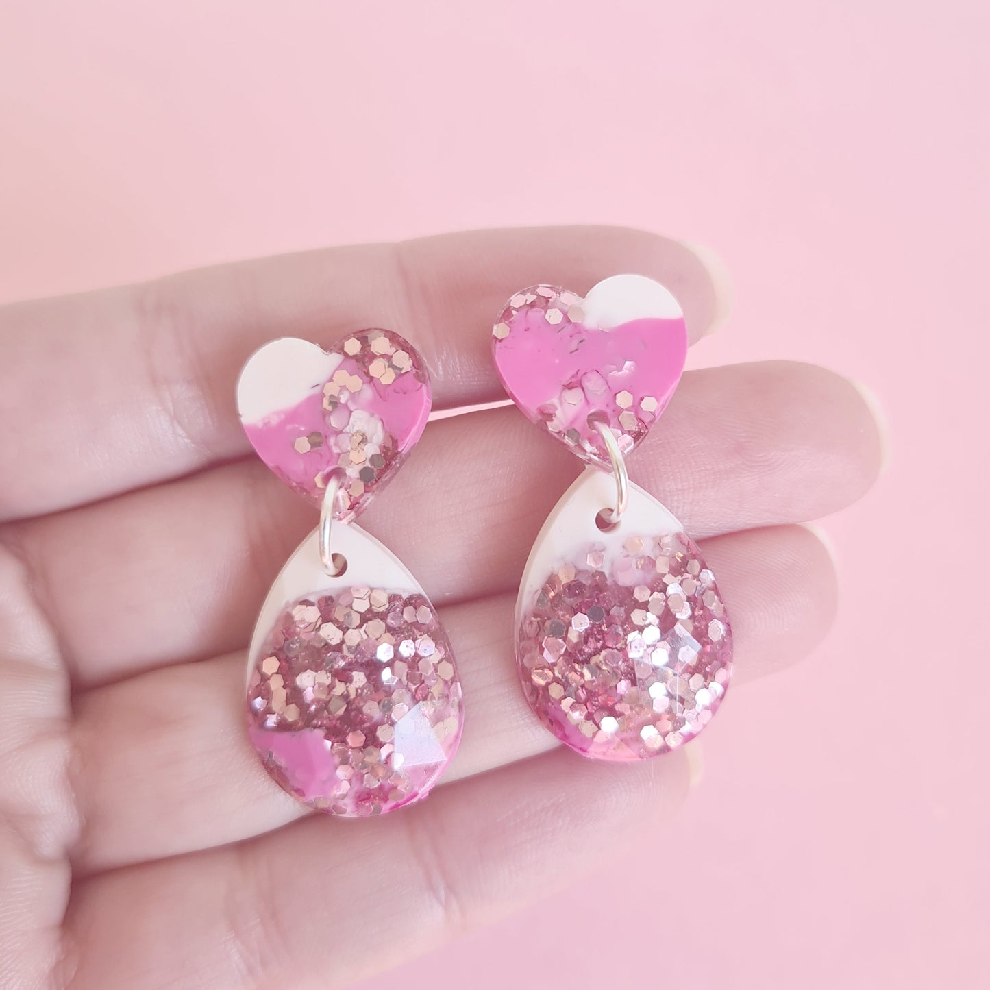 Pink marbled earring shown on the hand for scale